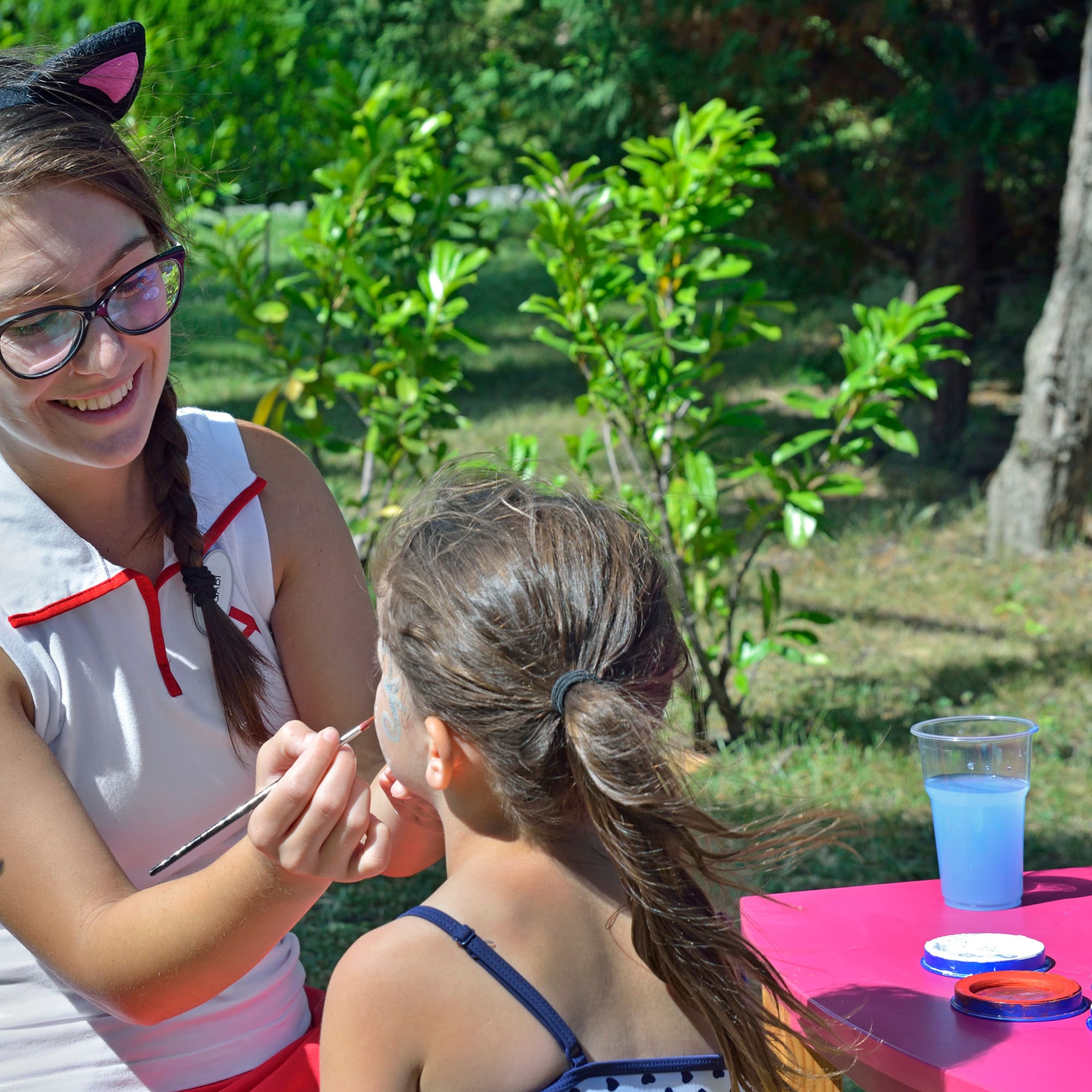 a woman painting a girl's face
