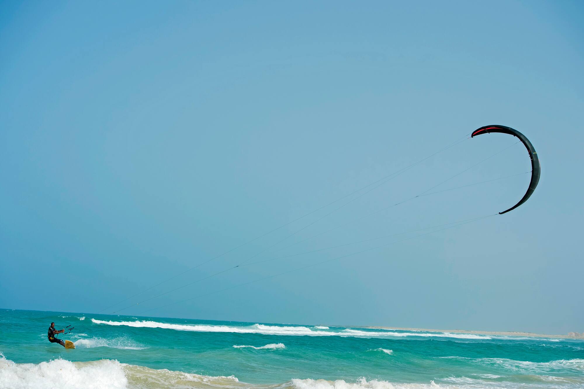 a person flying a kite over the ocean