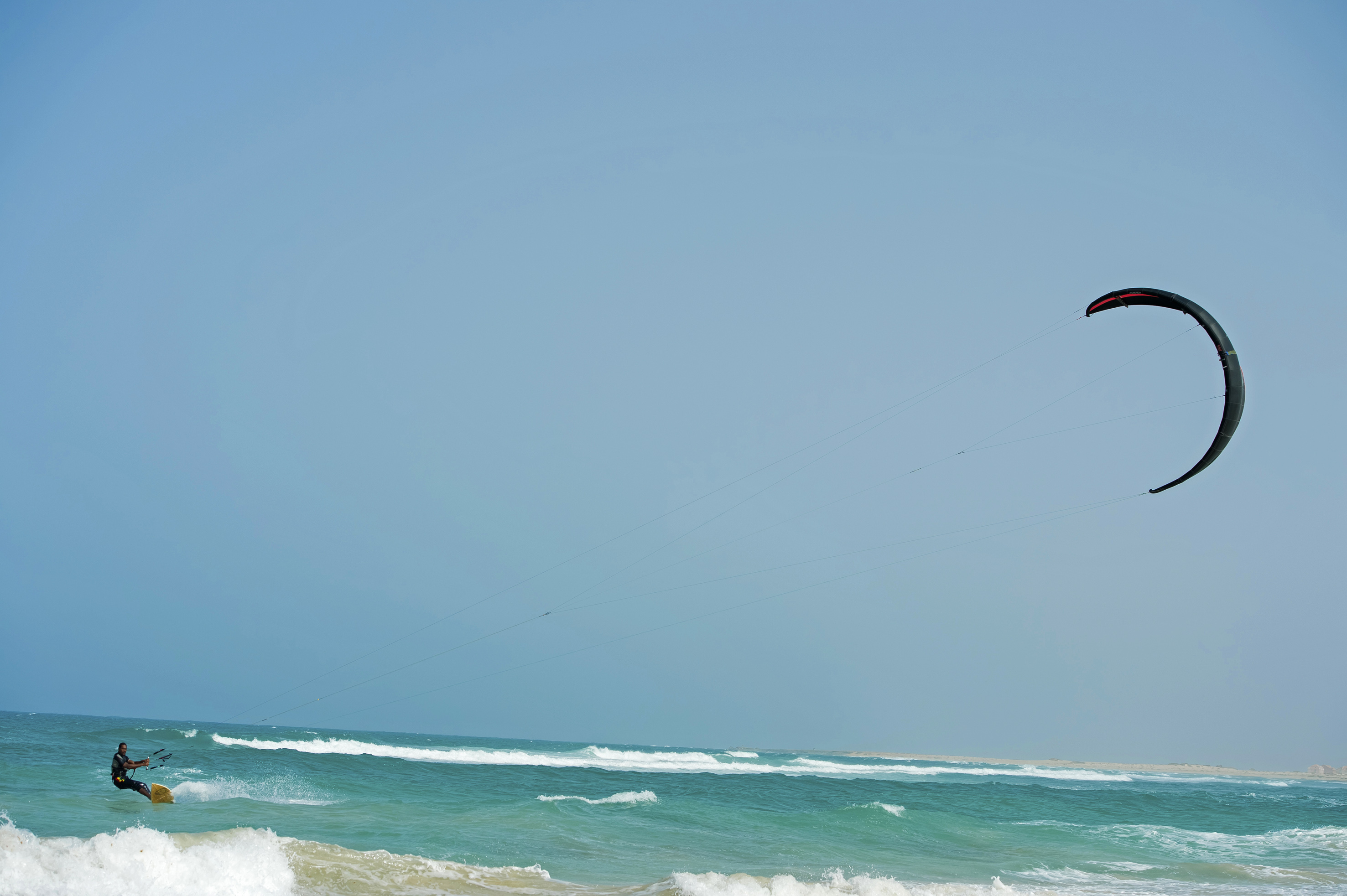 a person flying a kite over the ocean