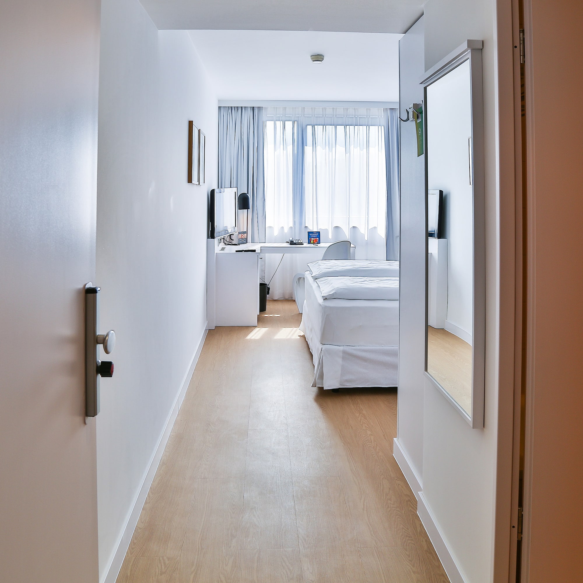a hallway with a bed and a mirror