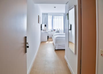 a hallway with a bed and a mirror
