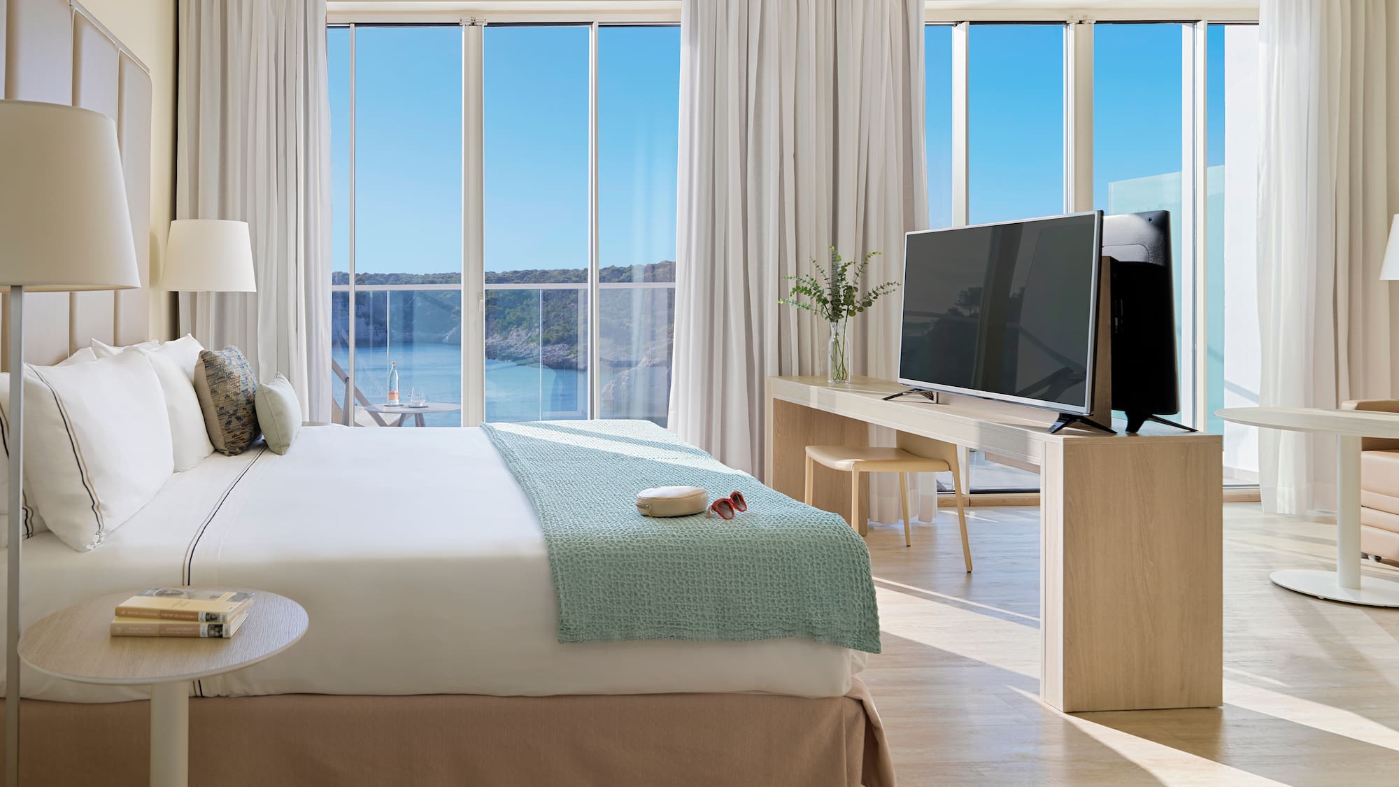 a bedroom with a television and a large window