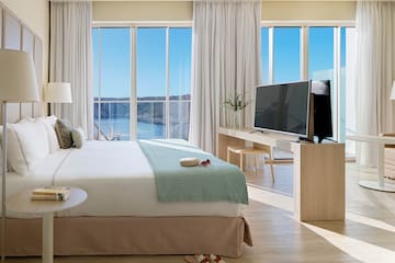 a bedroom with a television and a large window
