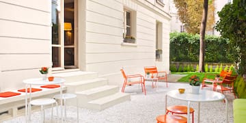 a white building with orange chairs and tables