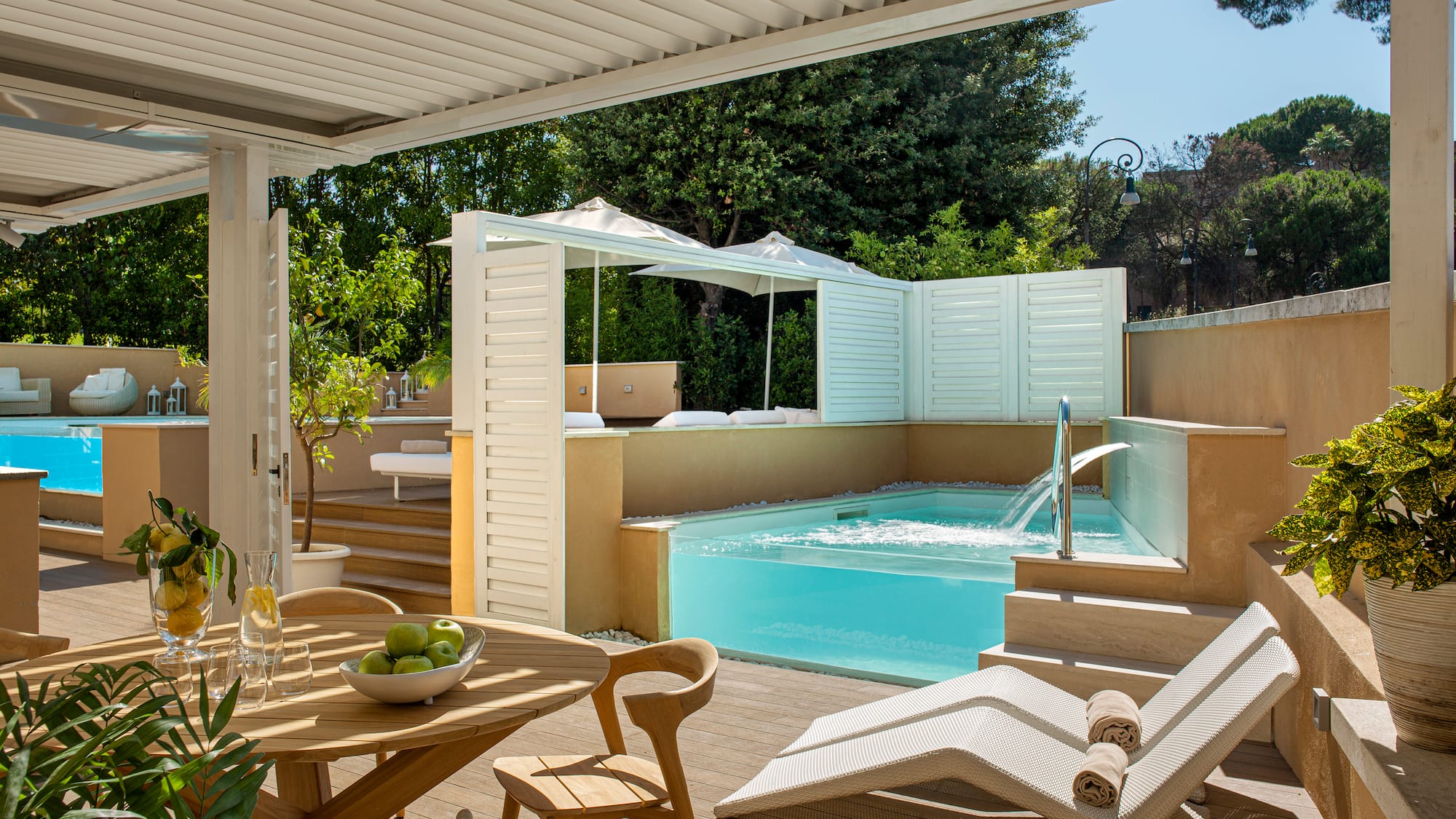 a patio with a pool and chairs