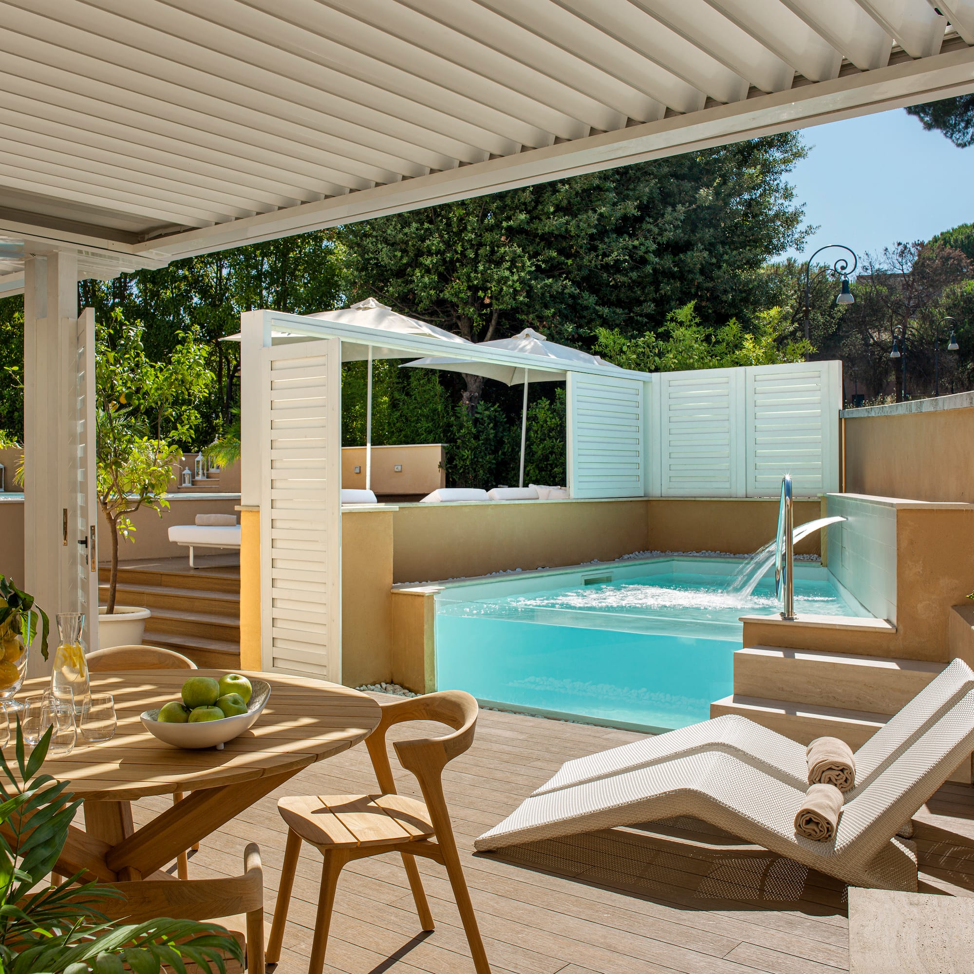 a patio with a pool and chairs
