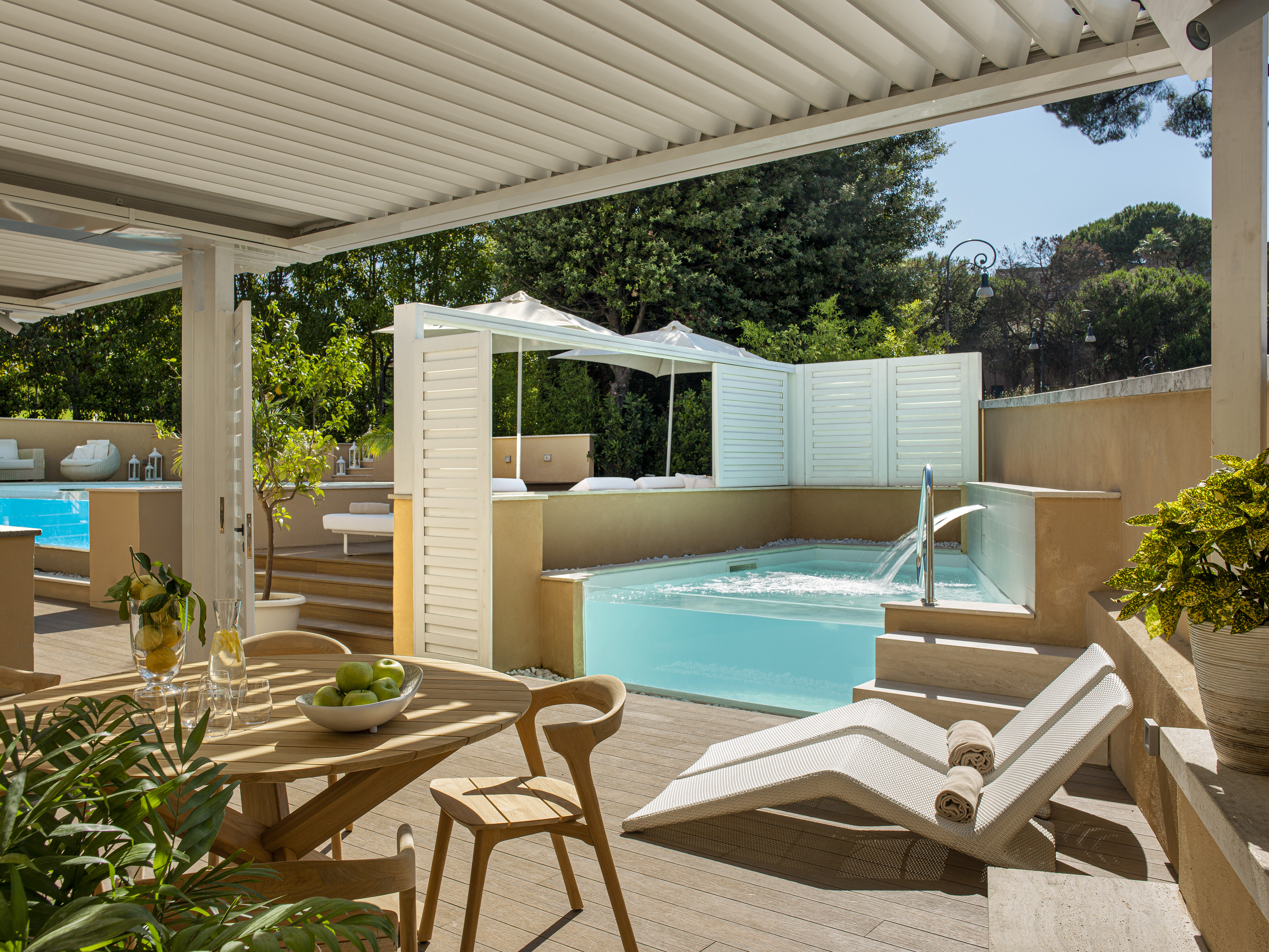 Luxury outdoor patio with private pool, pergola, lounge chairs, and dining area.