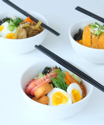 a group of bowls of food with chopsticks