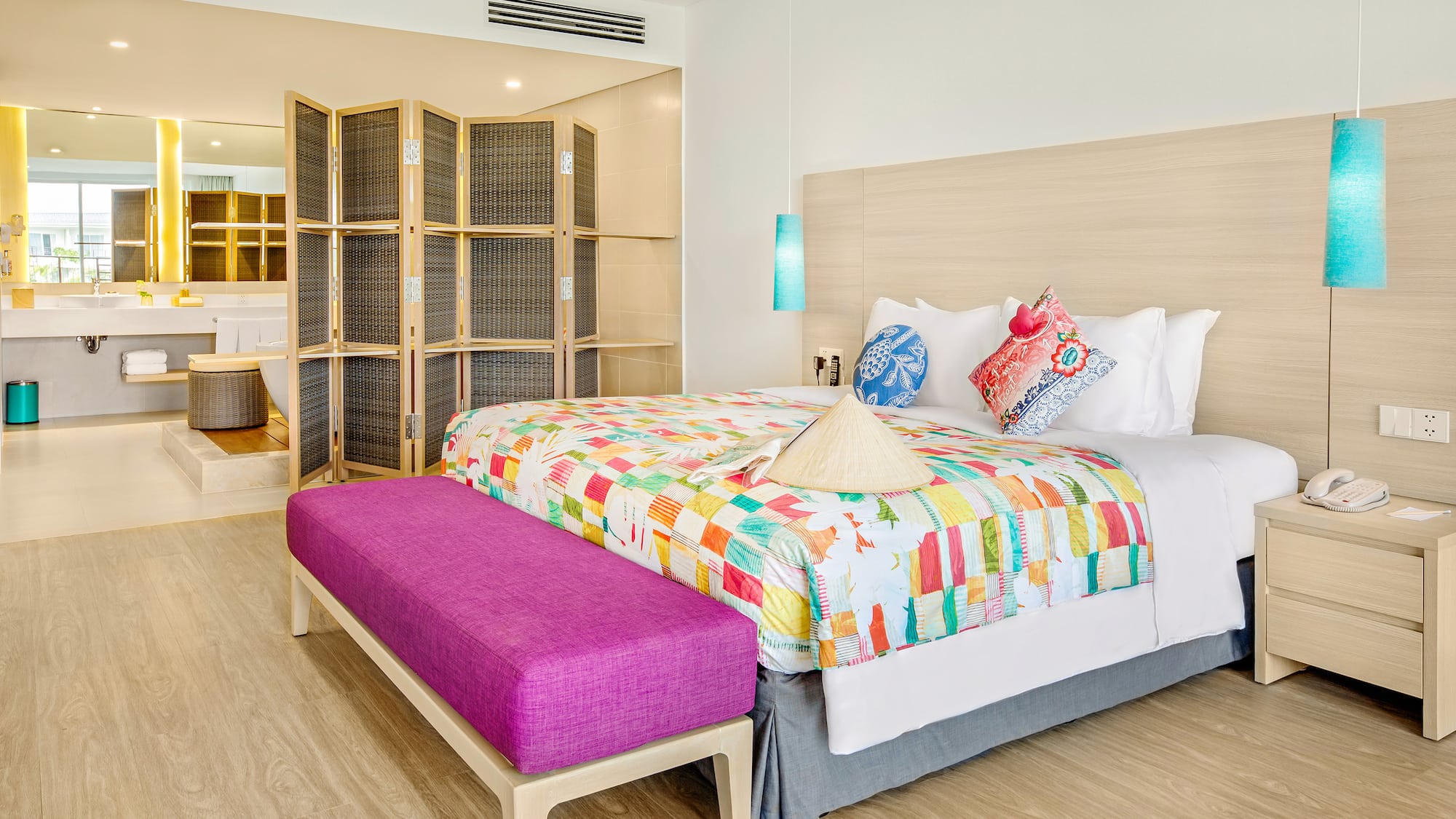 a bed with colorful blankets and a purple bench