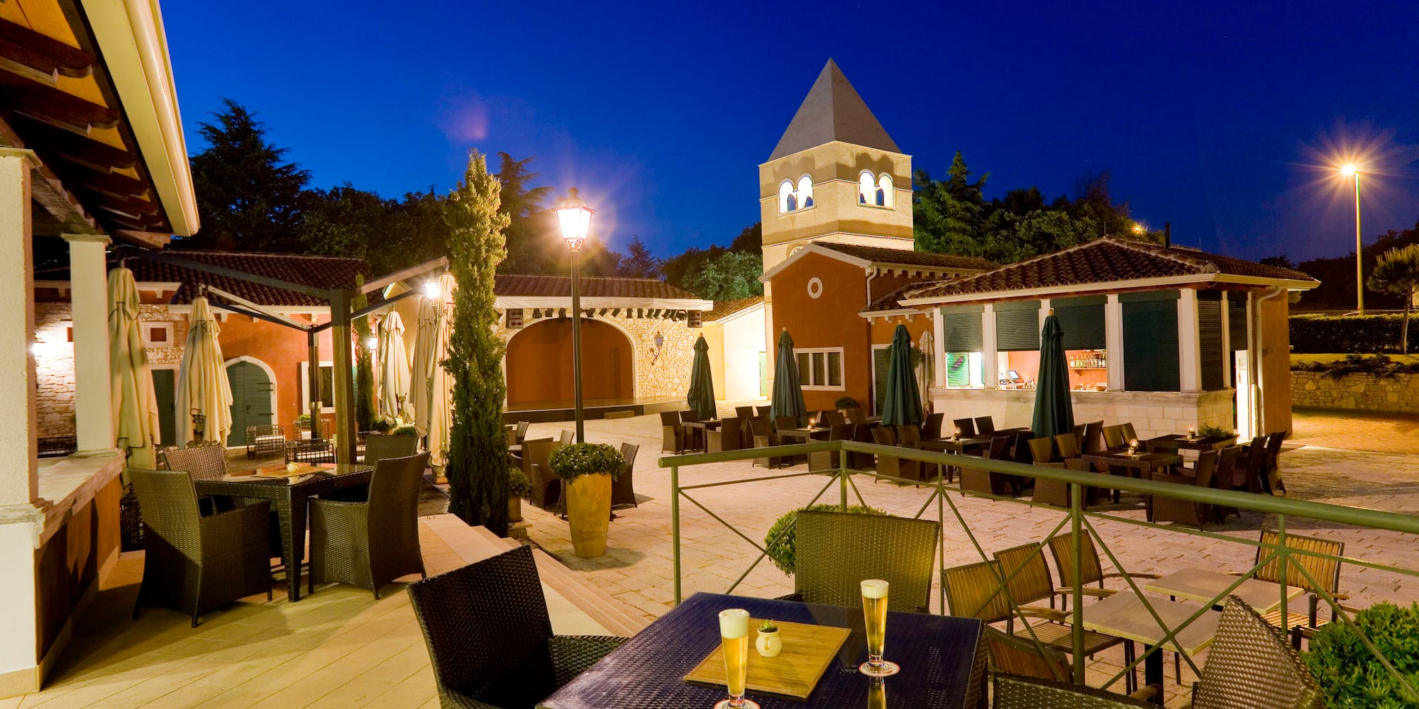 a patio with tables and chairs and a tower