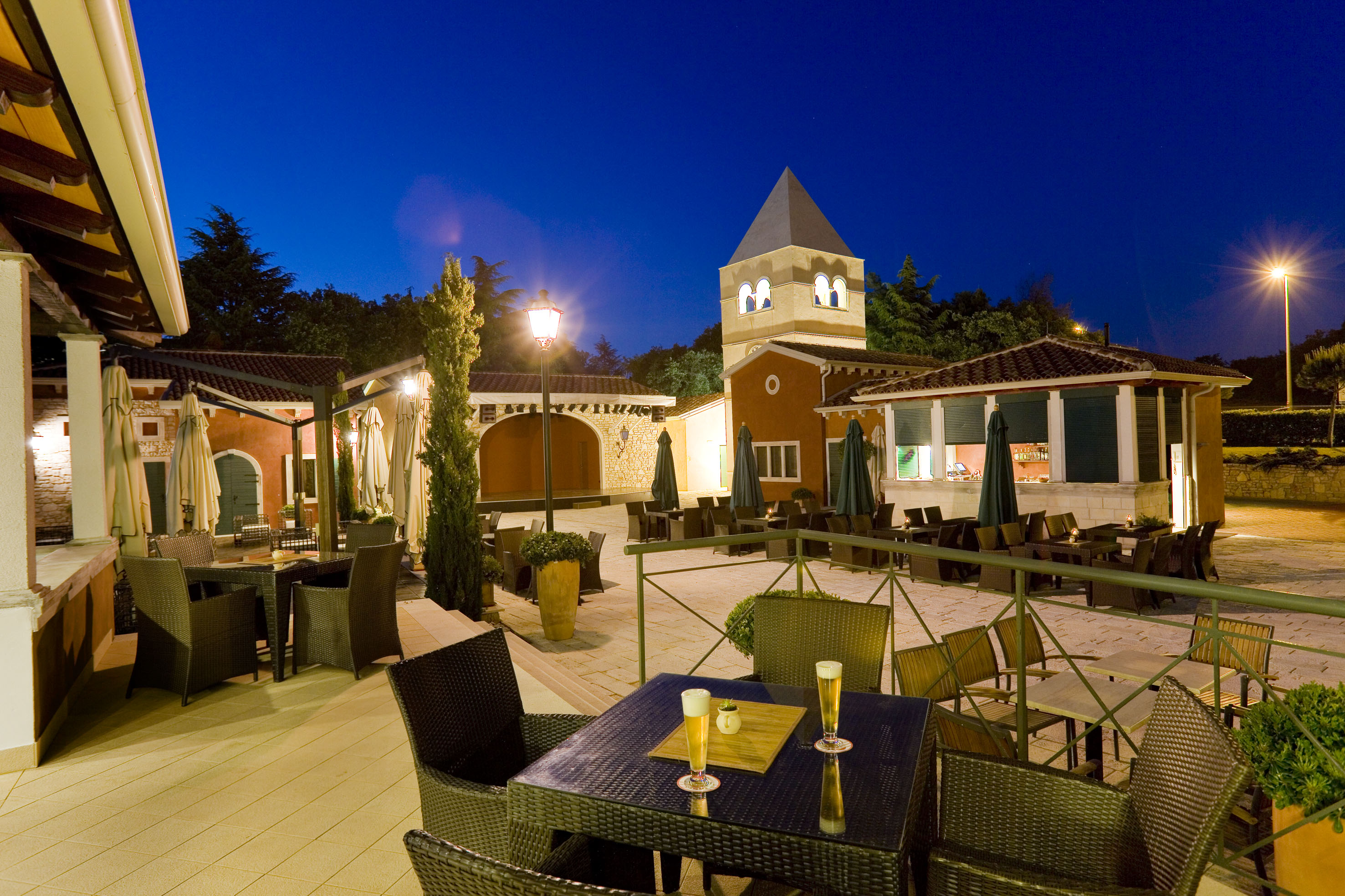 a patio with tables and chairs and a tower