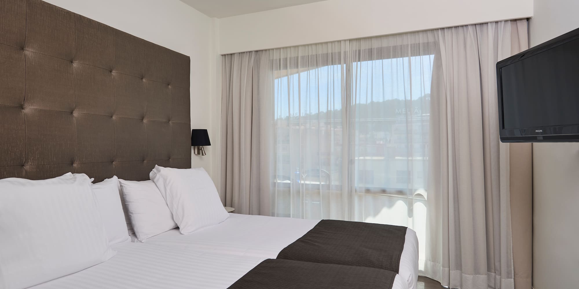 a bed with white sheets and black pillows