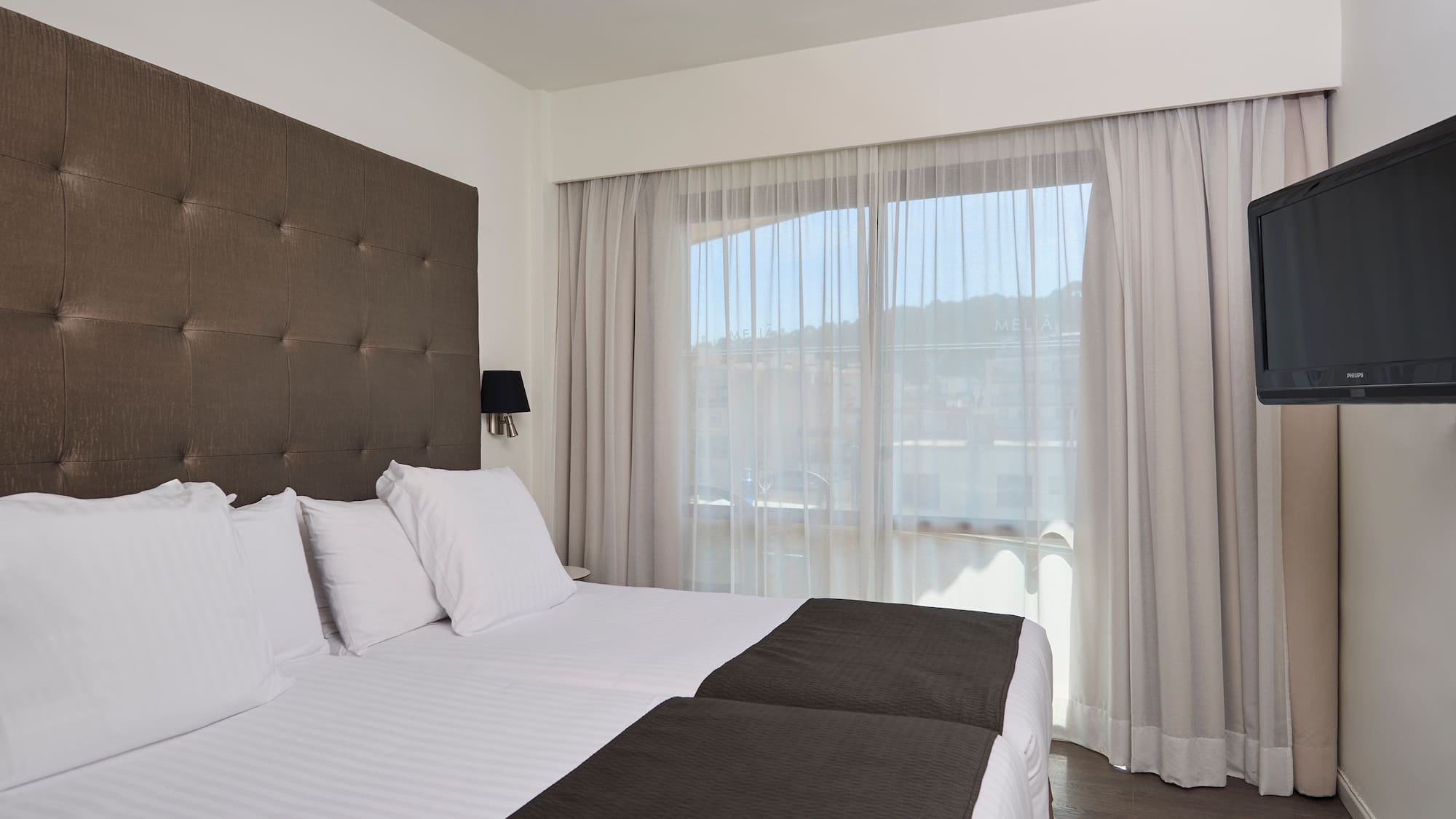 a bed with white sheets and black pillows