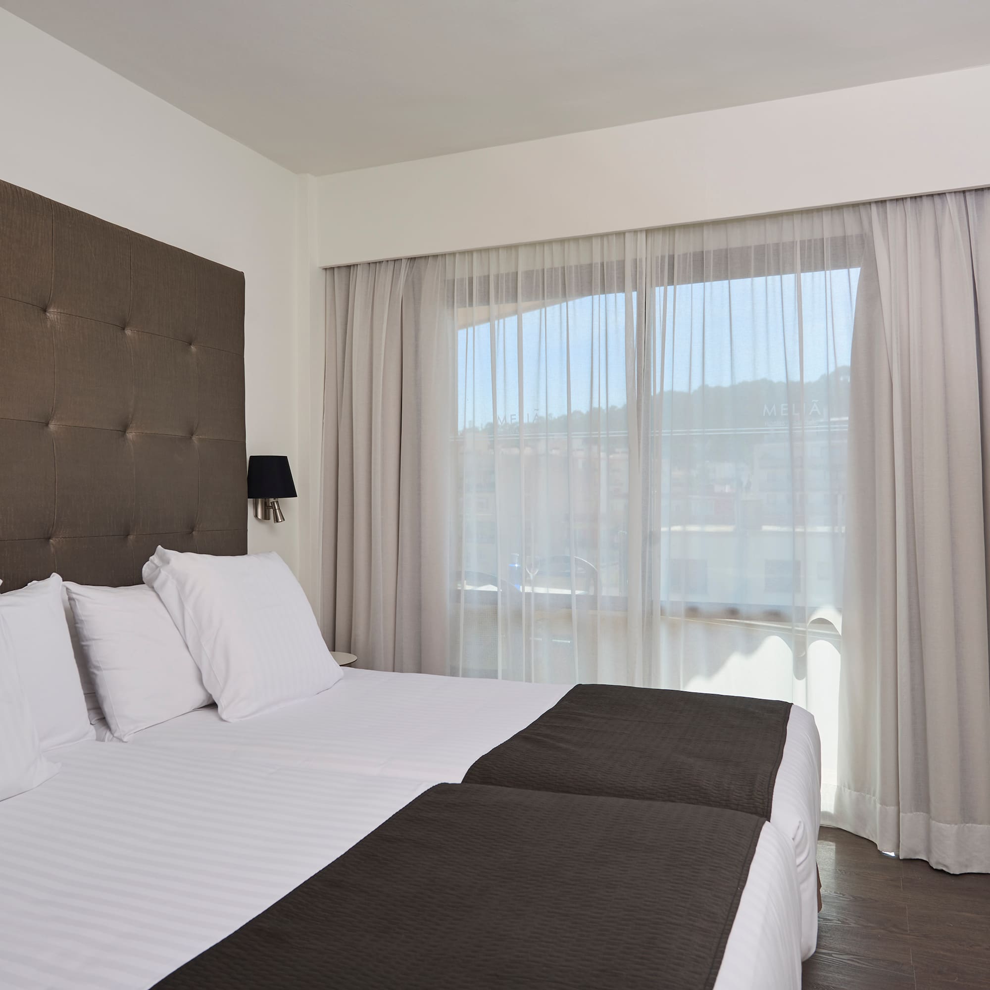 a bed with white sheets and black pillows