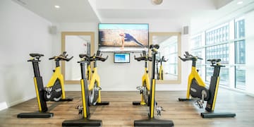 a room with exercise bikes and a tv