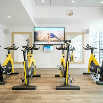 a room with exercise bikes and a tv