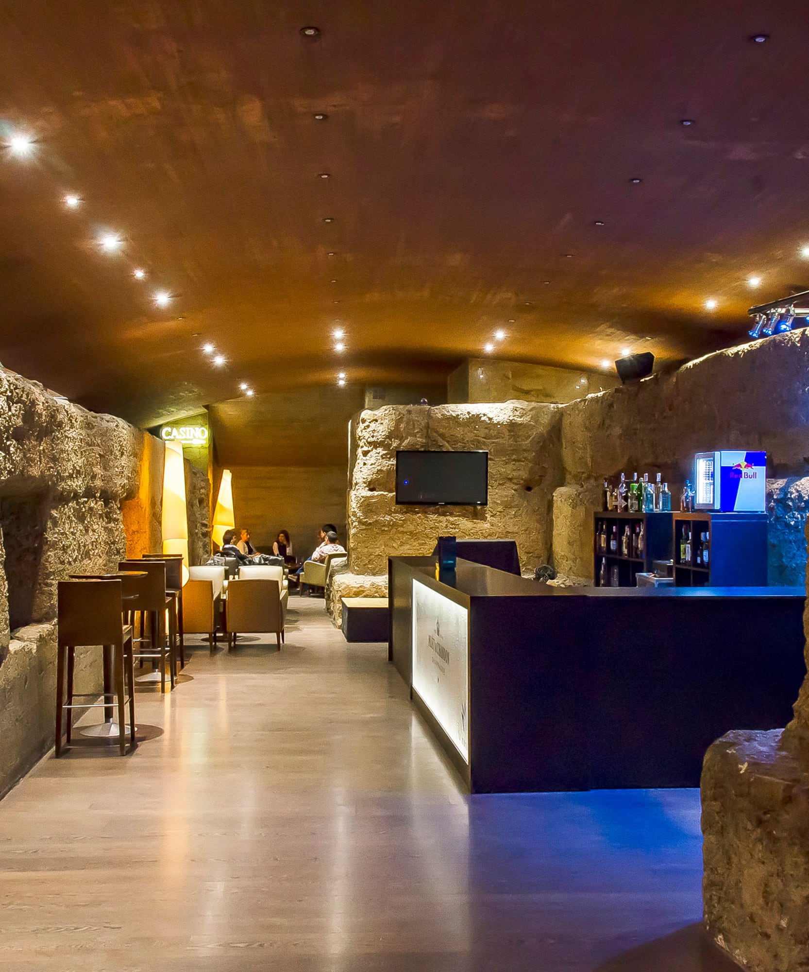 a room with a stone wall and tables and chairs