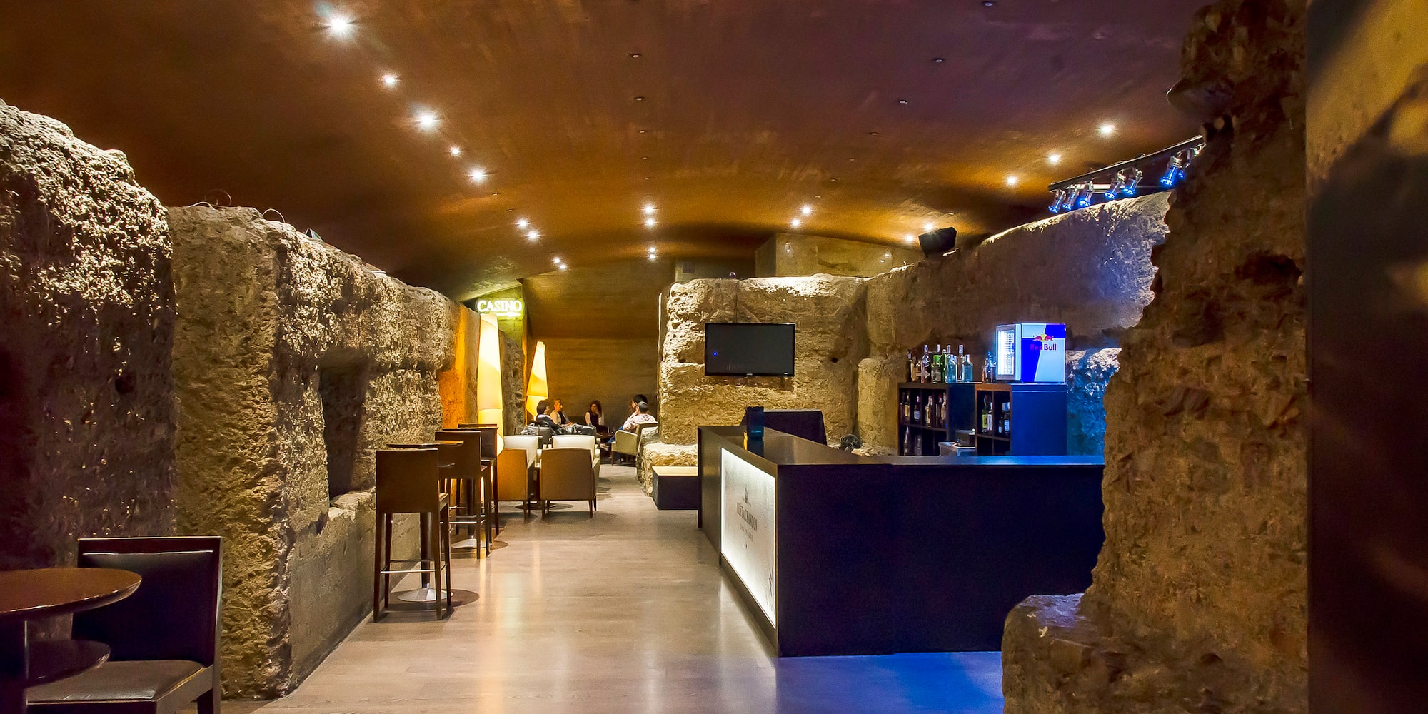 a room with a stone wall and tables and chairs