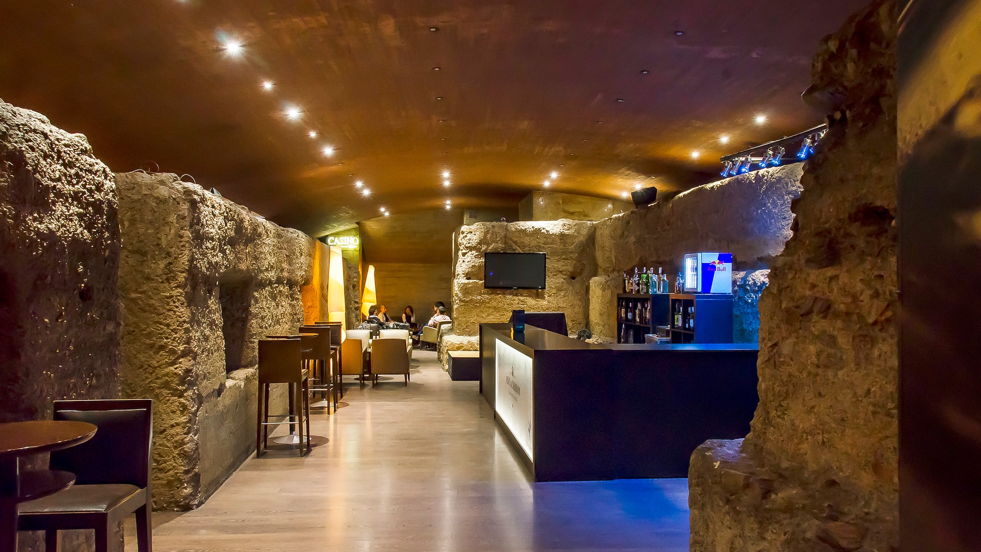 a room with a stone wall and tables and chairs