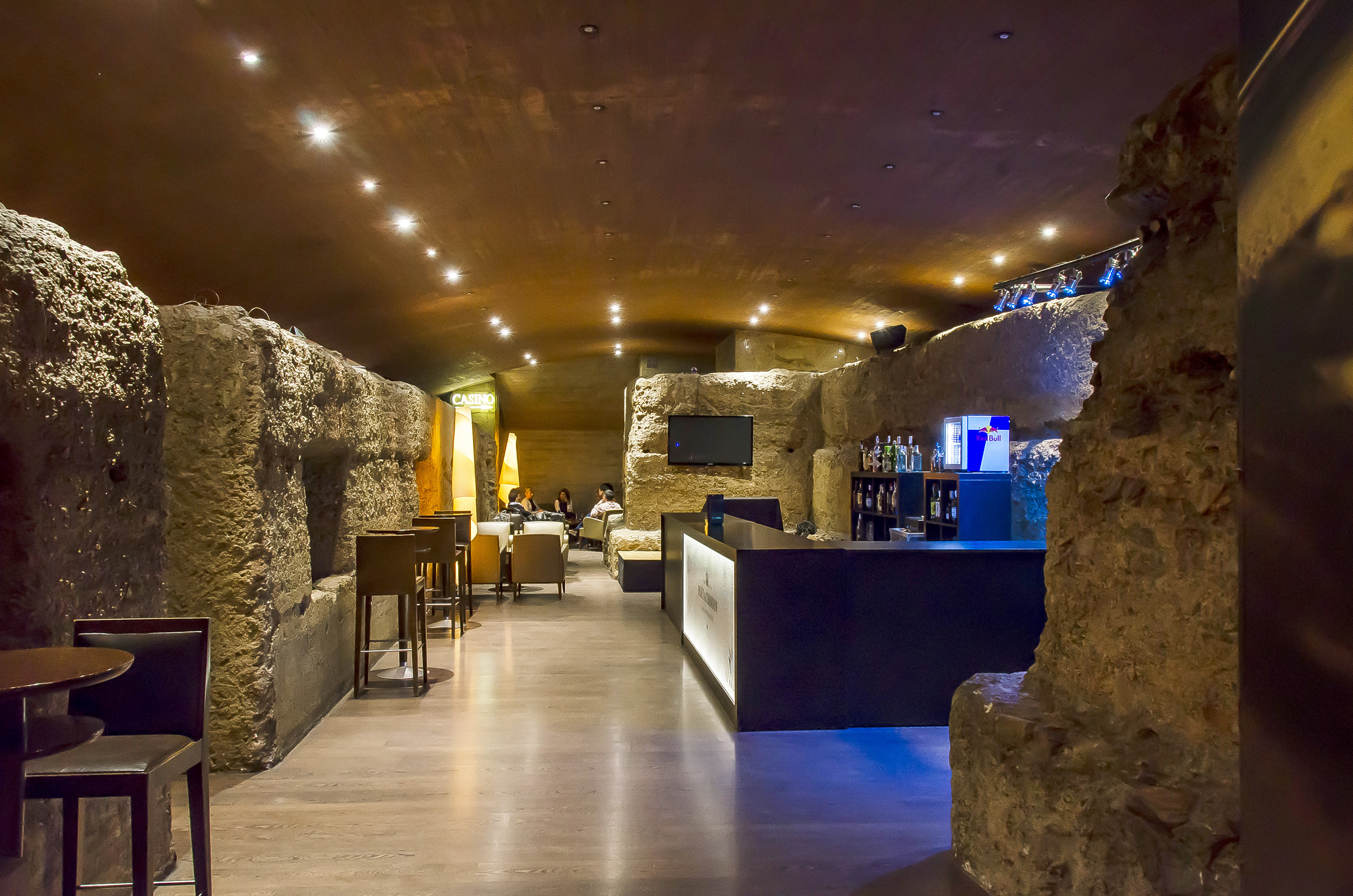 a room with a stone wall and tables and chairs