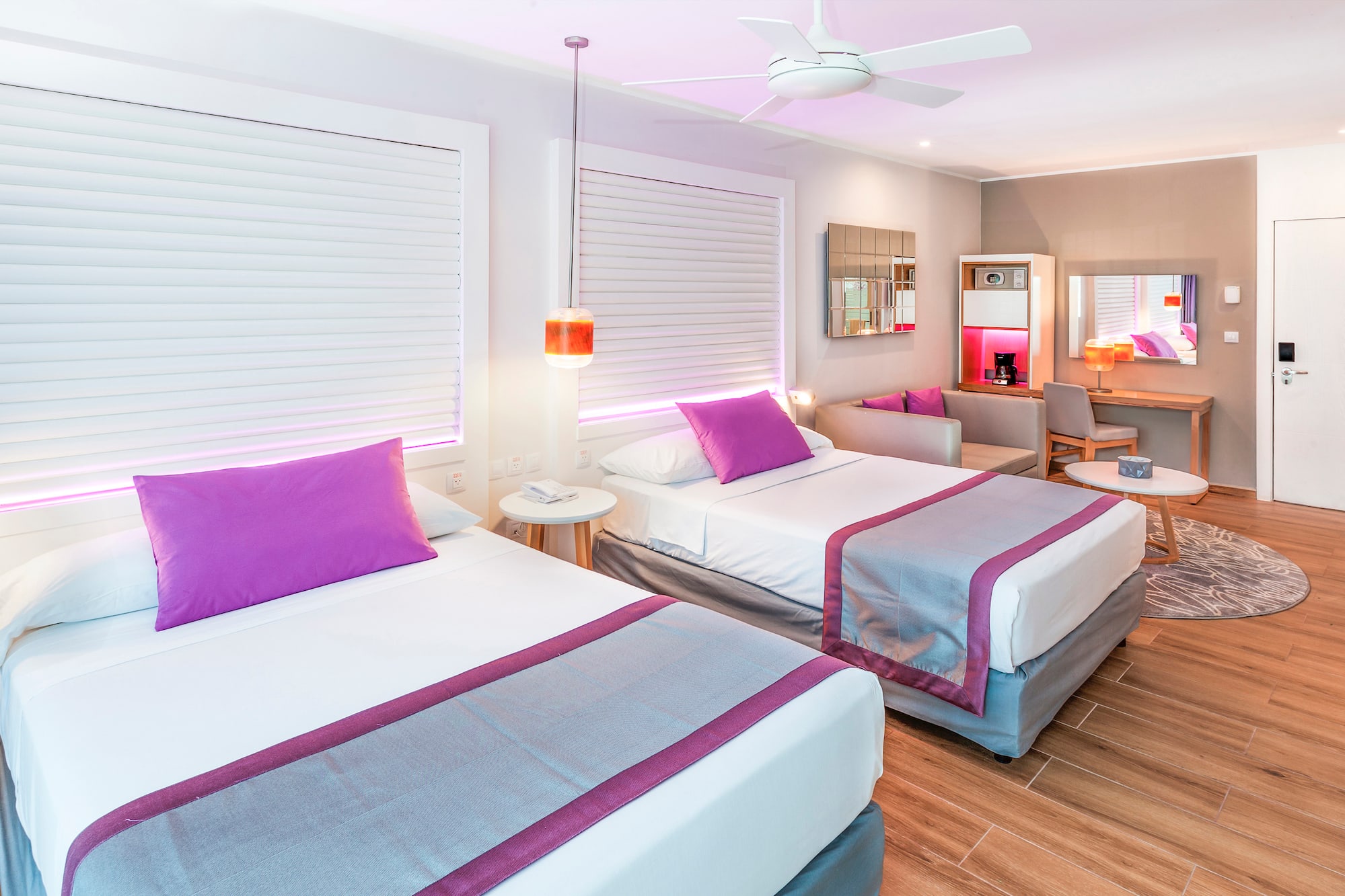 a room with two beds and a ceiling fan