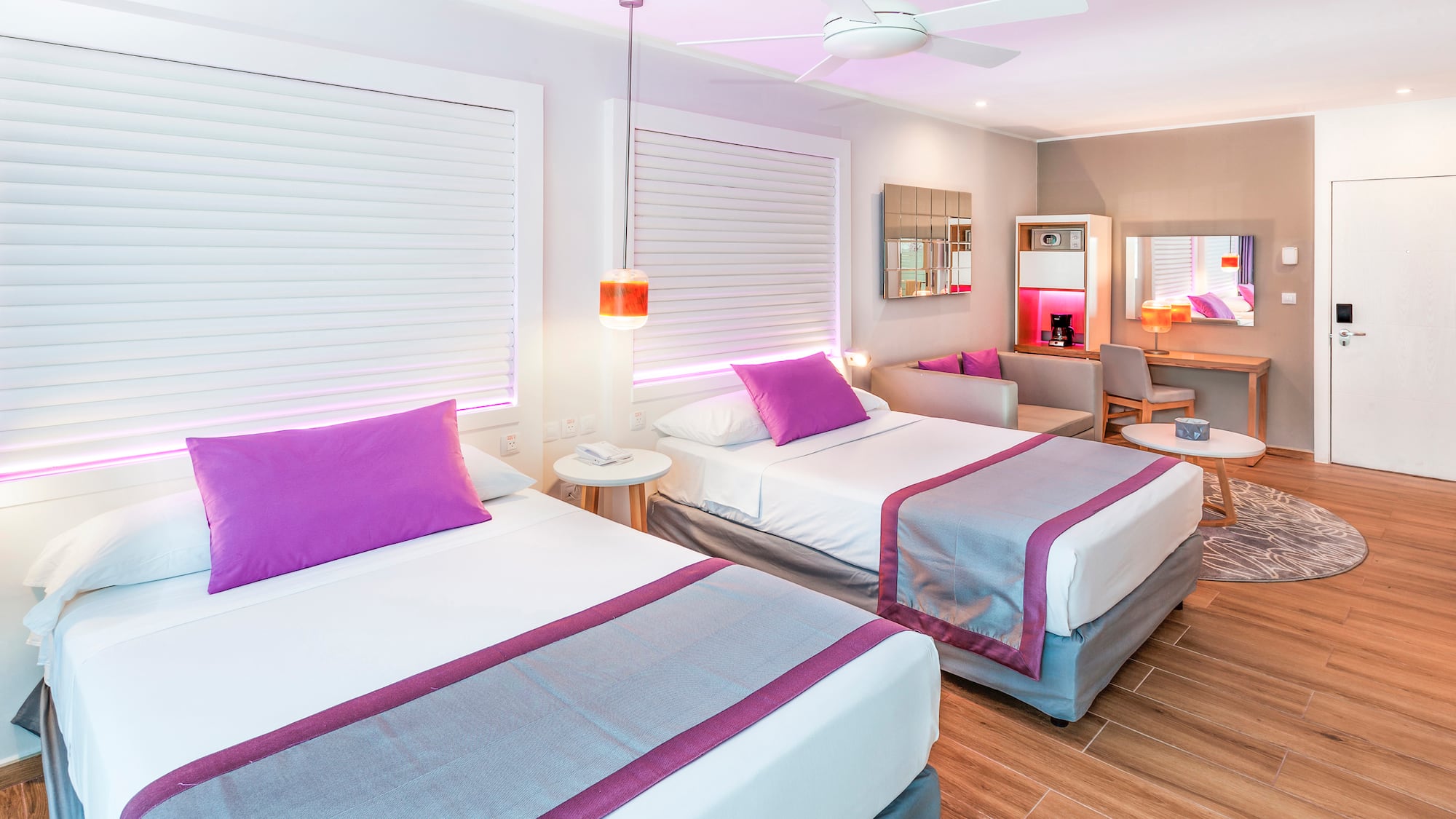 a room with two beds and a ceiling fan