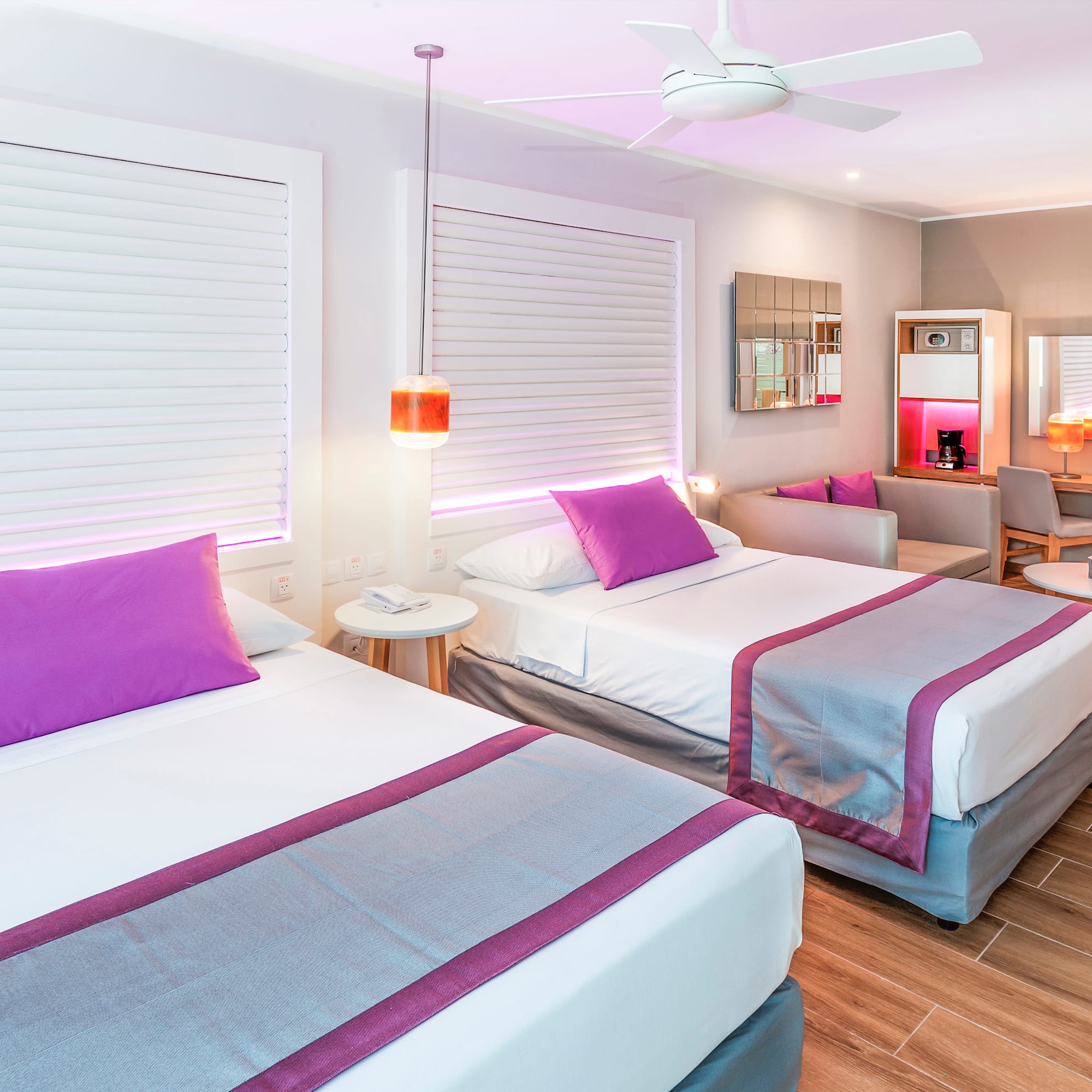 a room with two beds and a ceiling fan