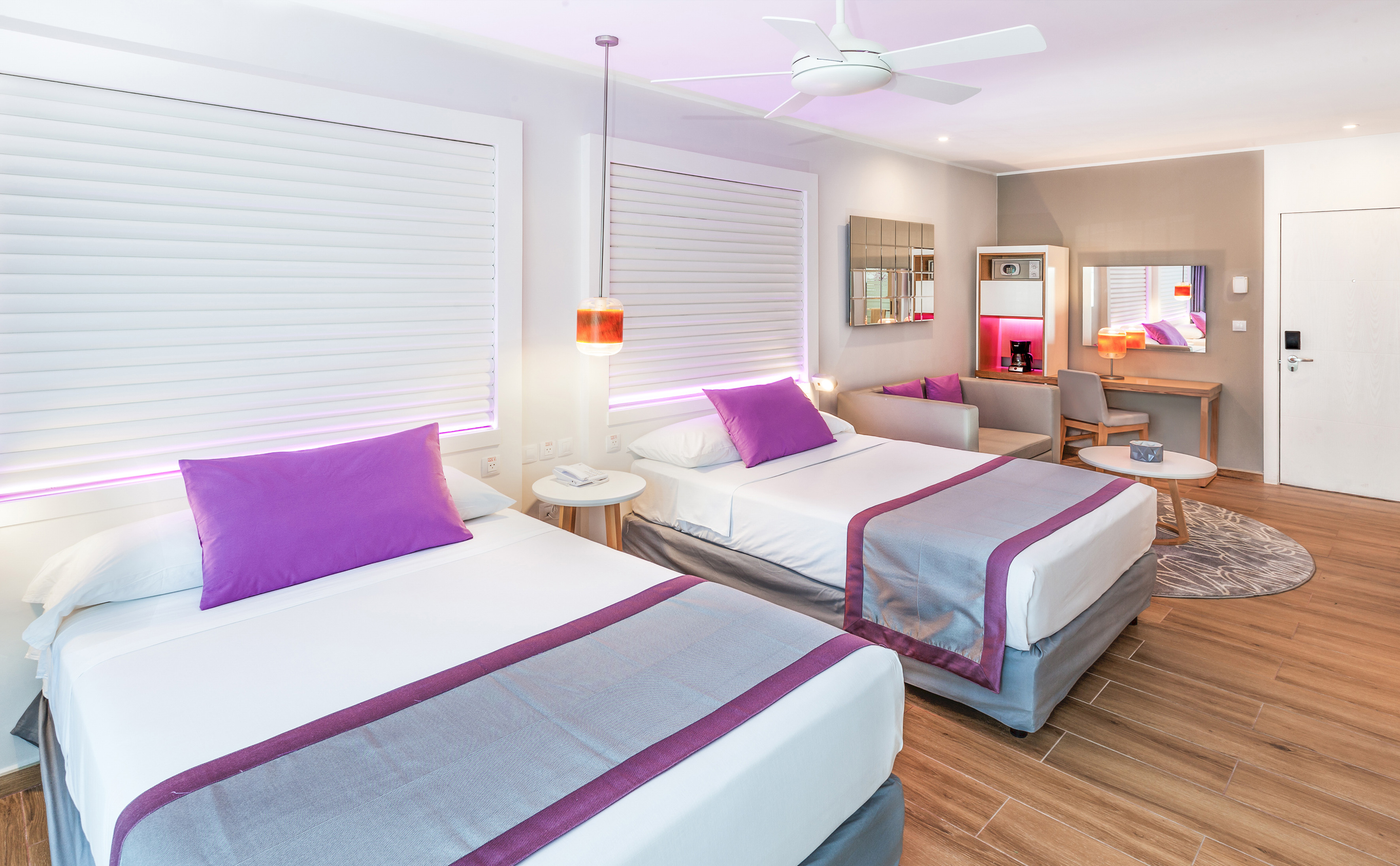 a room with two beds and a ceiling fan