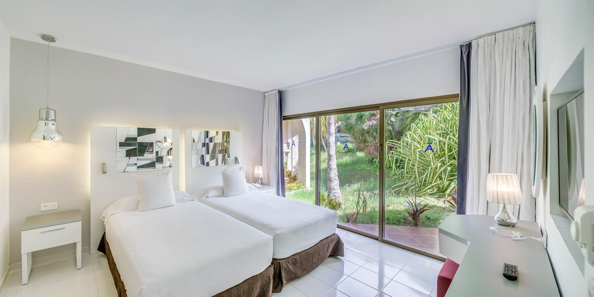 a room with two beds and a glass door