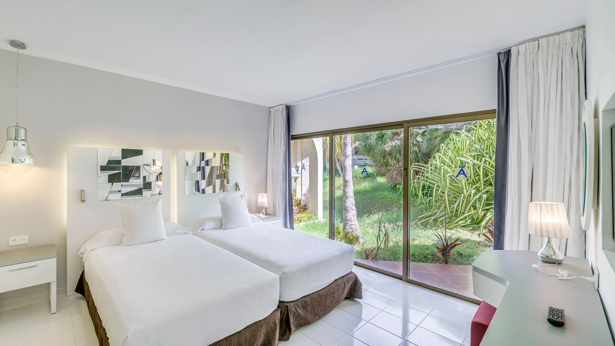 a room with two beds and a glass door