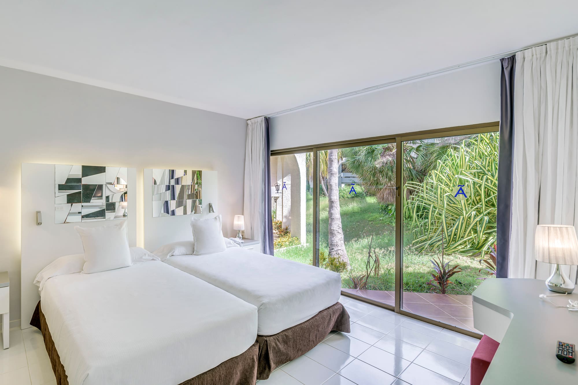 a room with two beds and a glass door