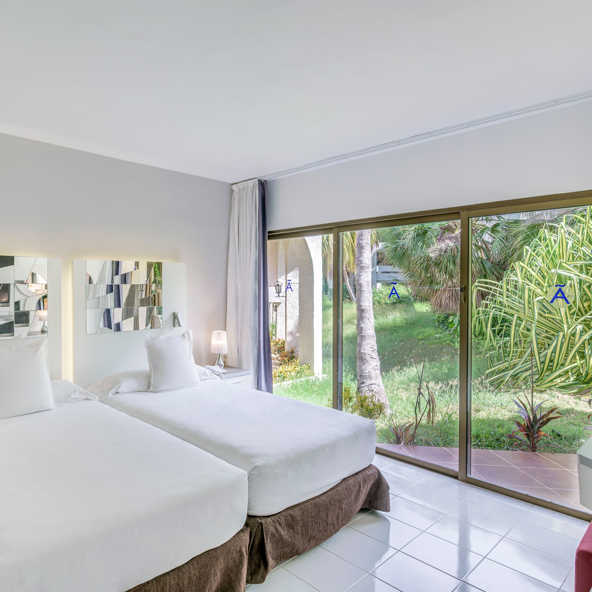 a room with two beds and a glass door