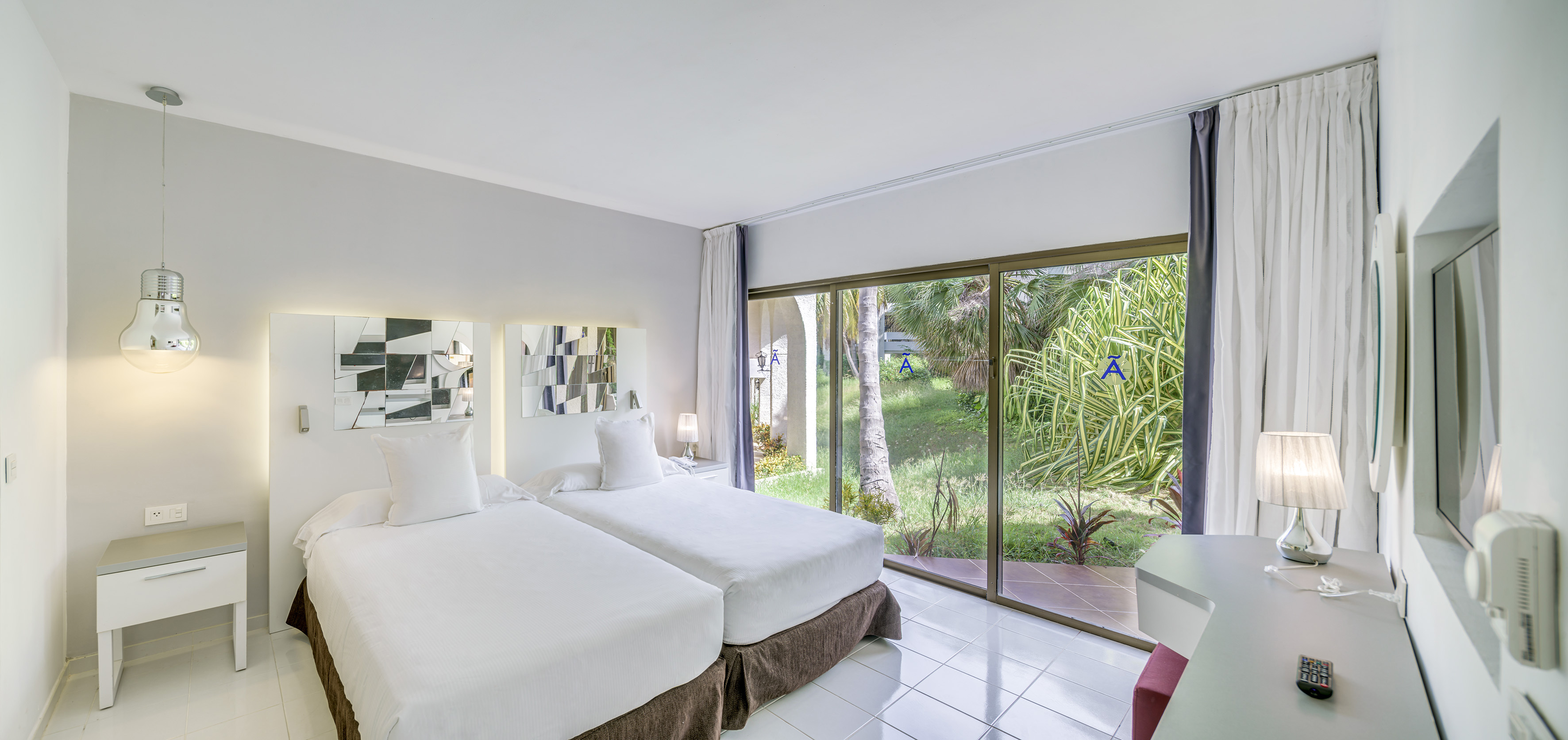 a room with two beds and a glass door