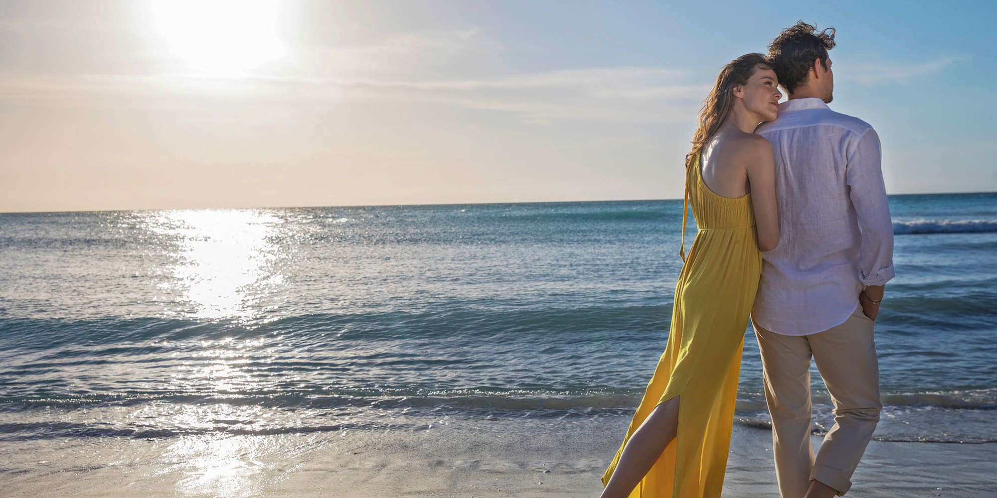 a man and woman standing on a beach