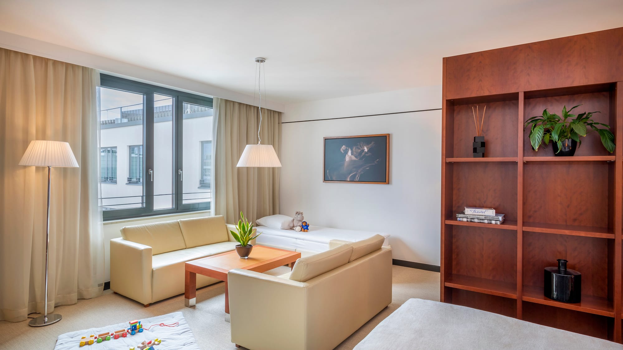 a living room with couches and a bookcase