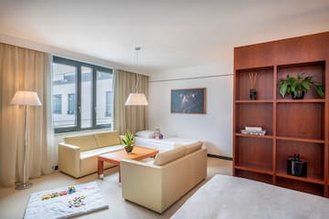 a living room with couches and a bookcase