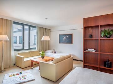 a living room with couches and a bookcase