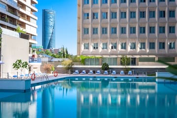 a pool with chairs and a building in the background