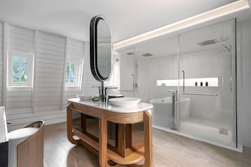 a bathroom with a large glass shower and a sink