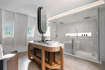 a bathroom with a large glass shower and a sink