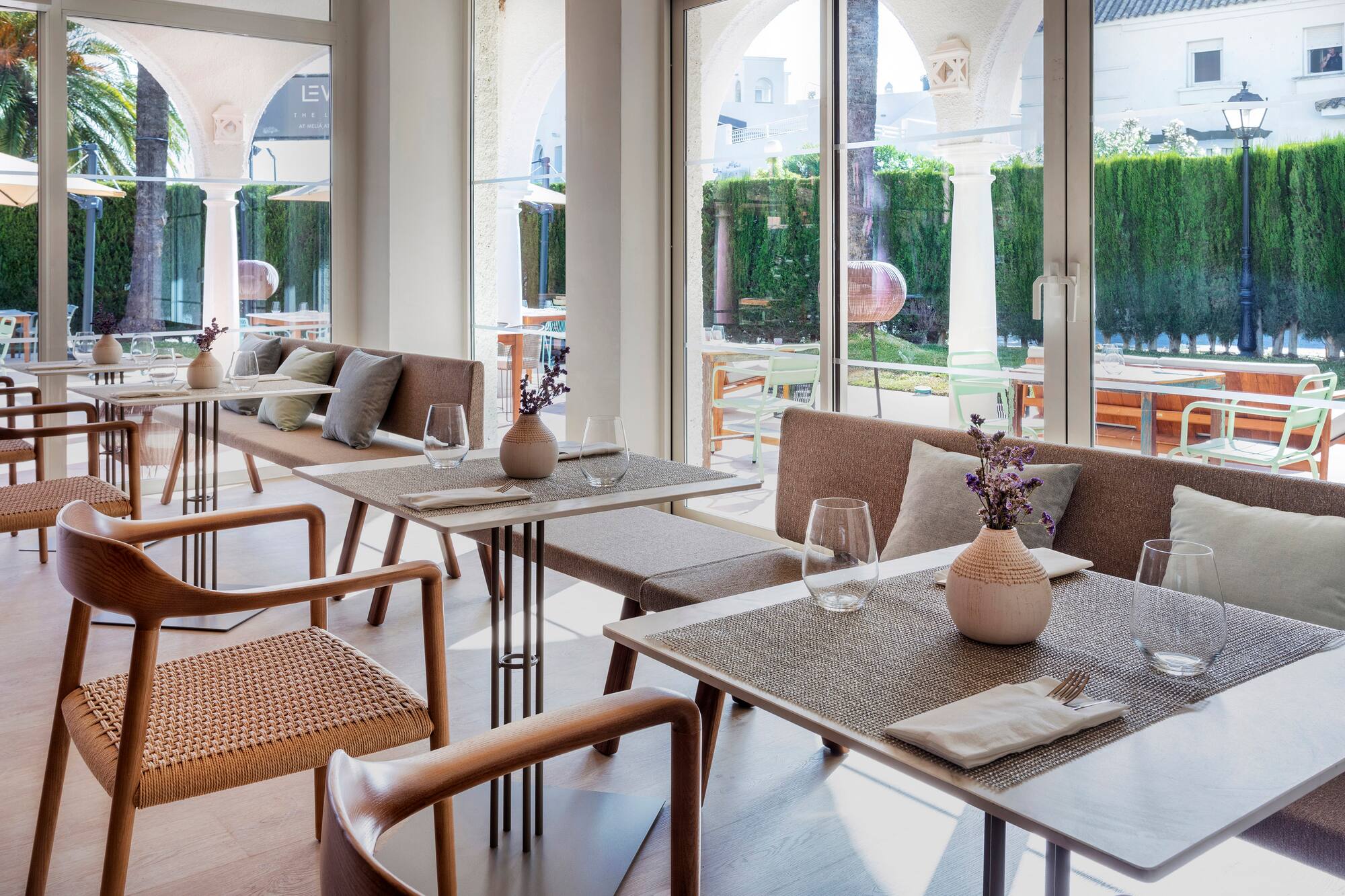 Elegant restaurant dining area with modern tables, seating, and sunny outdoor view.