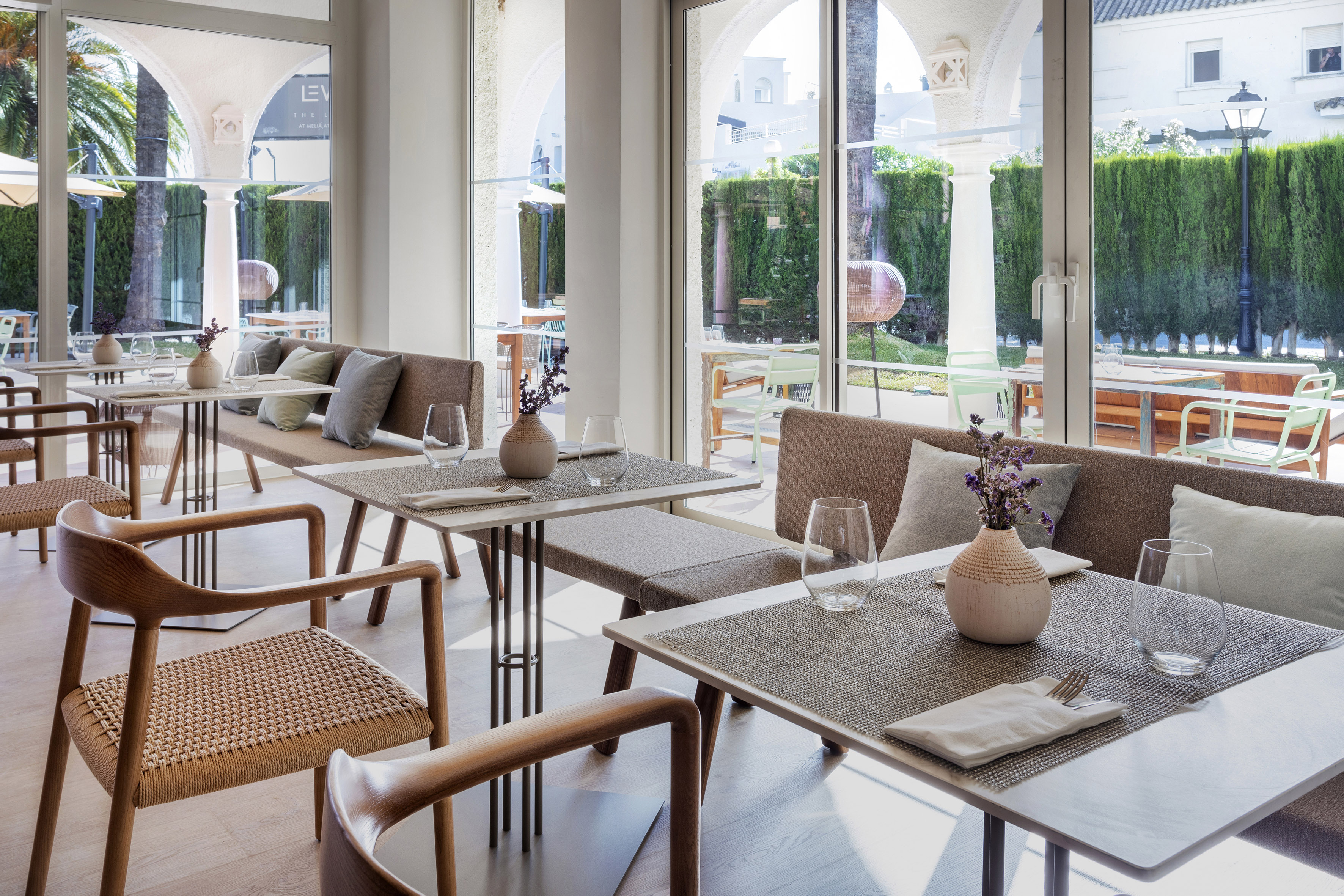 Elegant restaurant dining area with modern tables, seating, and sunny outdoor view.