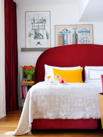 a bed with a red headboard and a red pillow
