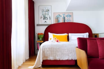 a bed with a red headboard and a red pillow