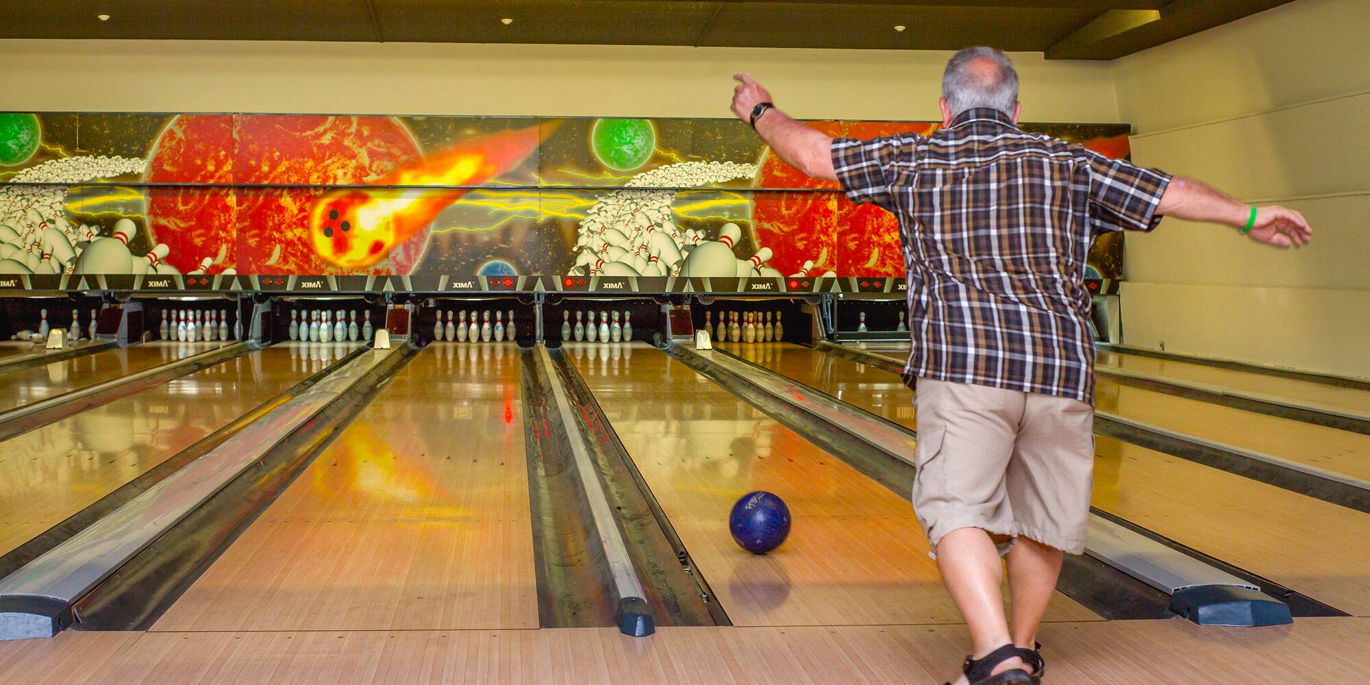 a man throwing a bowling ball