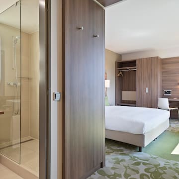 a room with a bed and a glass shower