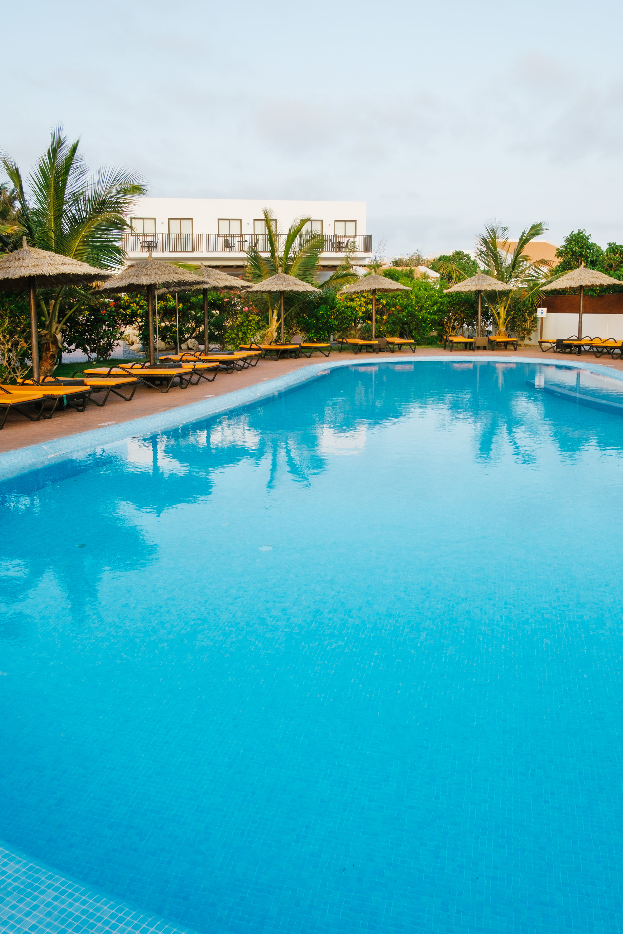 a pool with lounge chairs and umbrellas