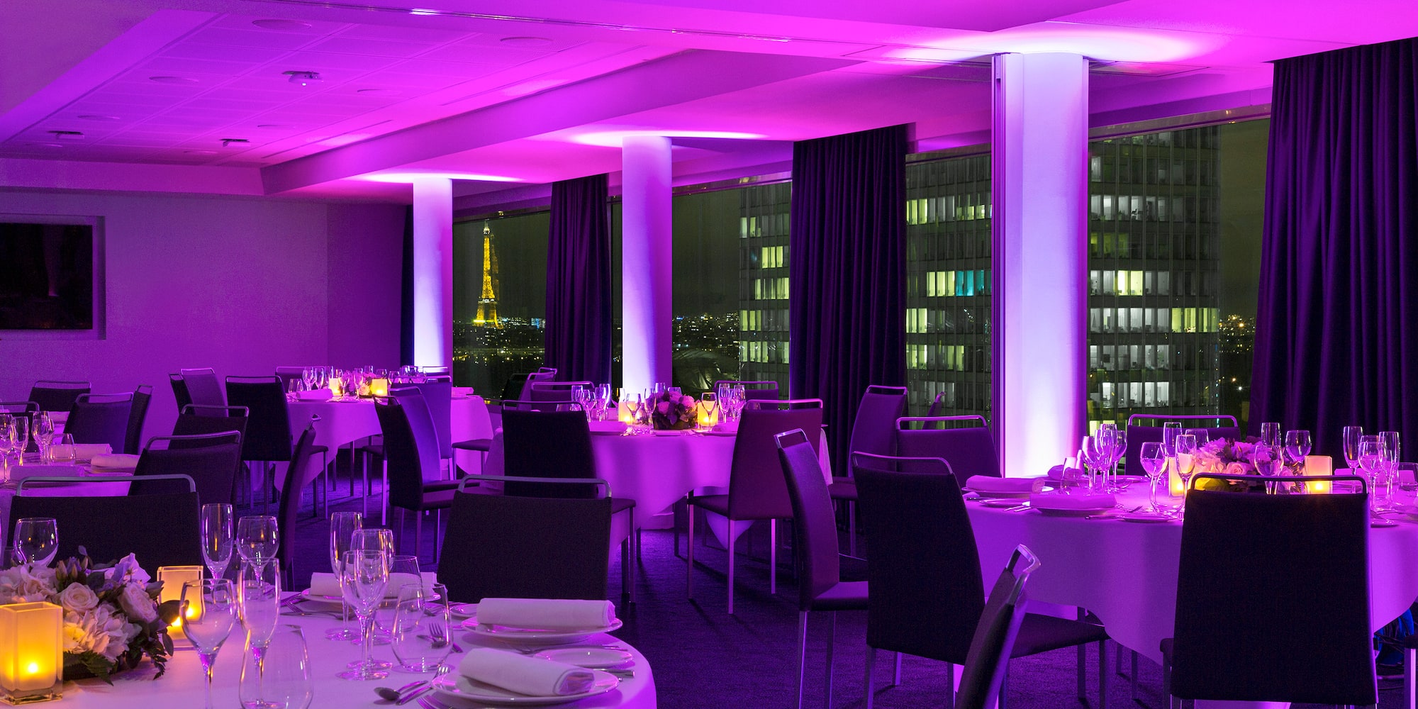 a room with tables and chairs and purple lights