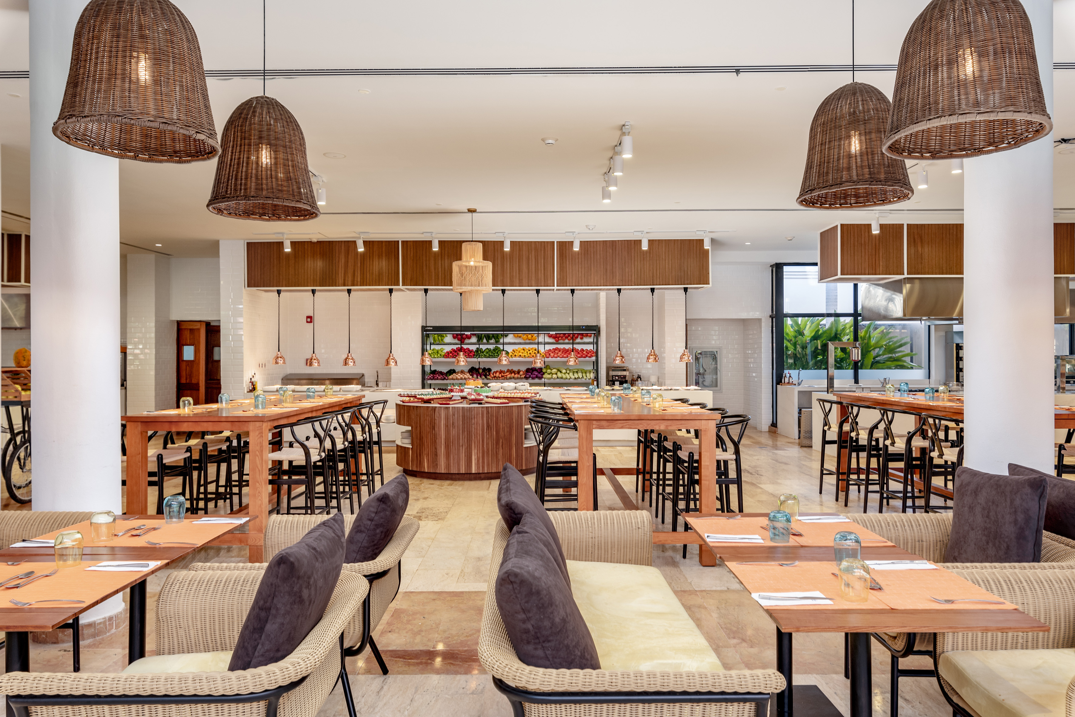 Modern restaurant with fresh food buffet, wicker lights, and varied seating.