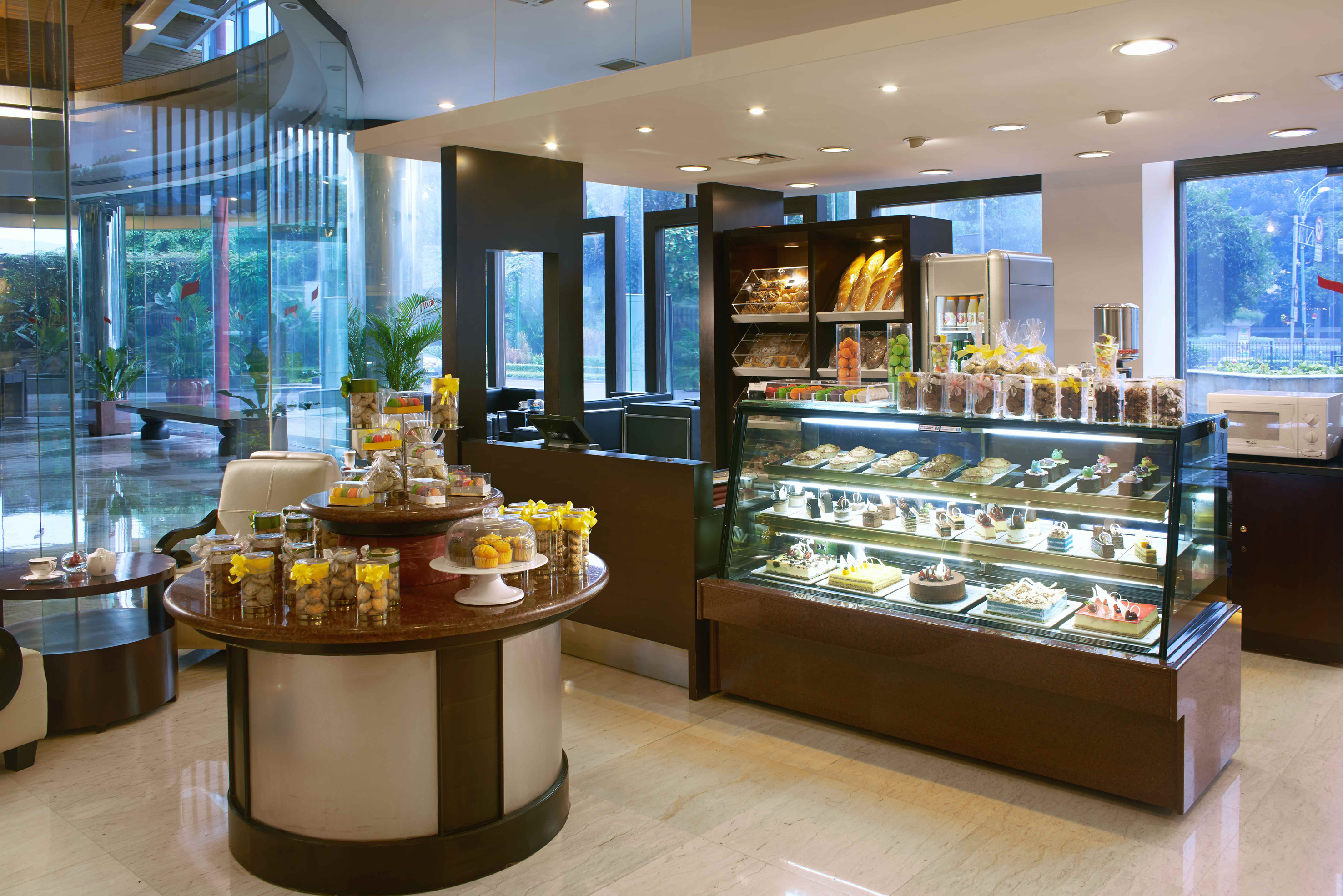 Modern hotel cafe with display of cakes, pastries, baked goods, and cookies.